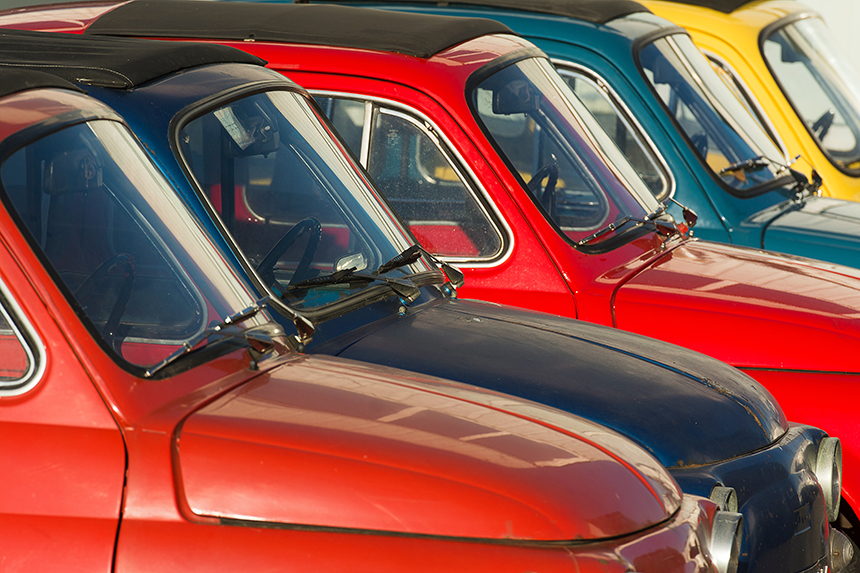 Classic Red Fiat 500 motor car with picnic basket parked on